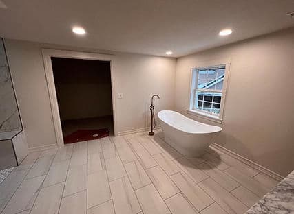 Modern bathroom featuring a freestanding bathtub, neutral colors, and natural light.