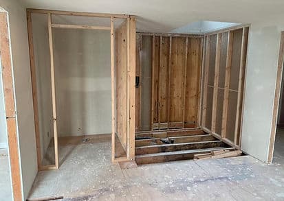 Home renovation progress showing framed walls in an unfinished indoor space.